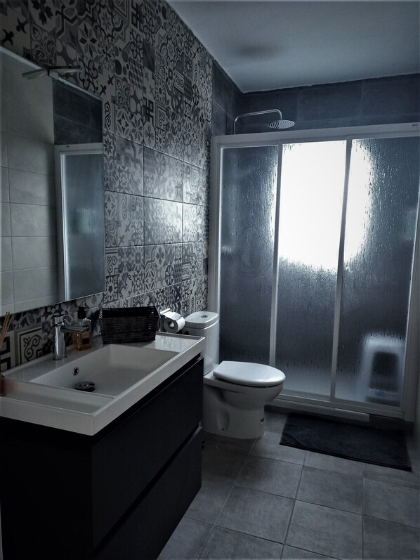 A modern bathroom with a large sink, toilet, and a shower area. - Come have some fun with us (Castejón de Valdejasa)