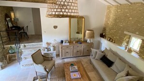 Uma sala de estar ampla, com sofá, cadeiras, mesa de centro e parede de pedra.