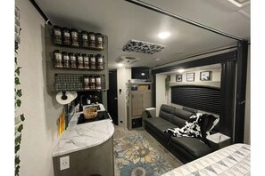 Cozy living space with a kitchenette, sofa, and TV.