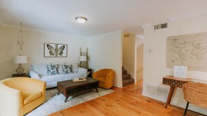 A living room with a sofa, two armchairs, a coffee table, and a world map on the wall. - 2BD-3BA-3BEDS in the PERFECT location in Ocean Springs! Britt's Creek Condo (Ocean Springs)