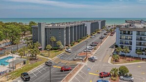 A multi-story hotel with a parking lot, a swimming pool, and a view of the ocean. - NEW! Ocean-Front Resort, Steps From Beach, 6 pools and Lazy River (Myrtle Beach)