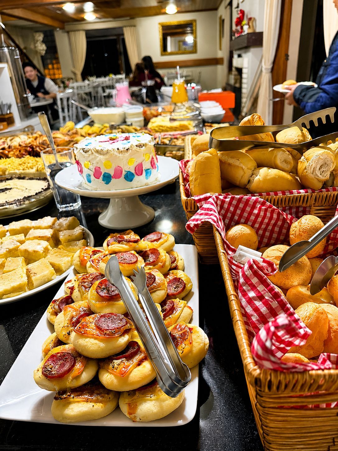 A buffet with various food items including a cake, bread, and pastries.