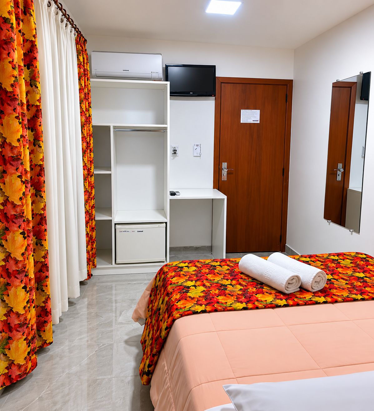 Une chambre d’hôtel équipée d’un lit, d’un bureau, d’une armoire et d’un appareil de climatisation.