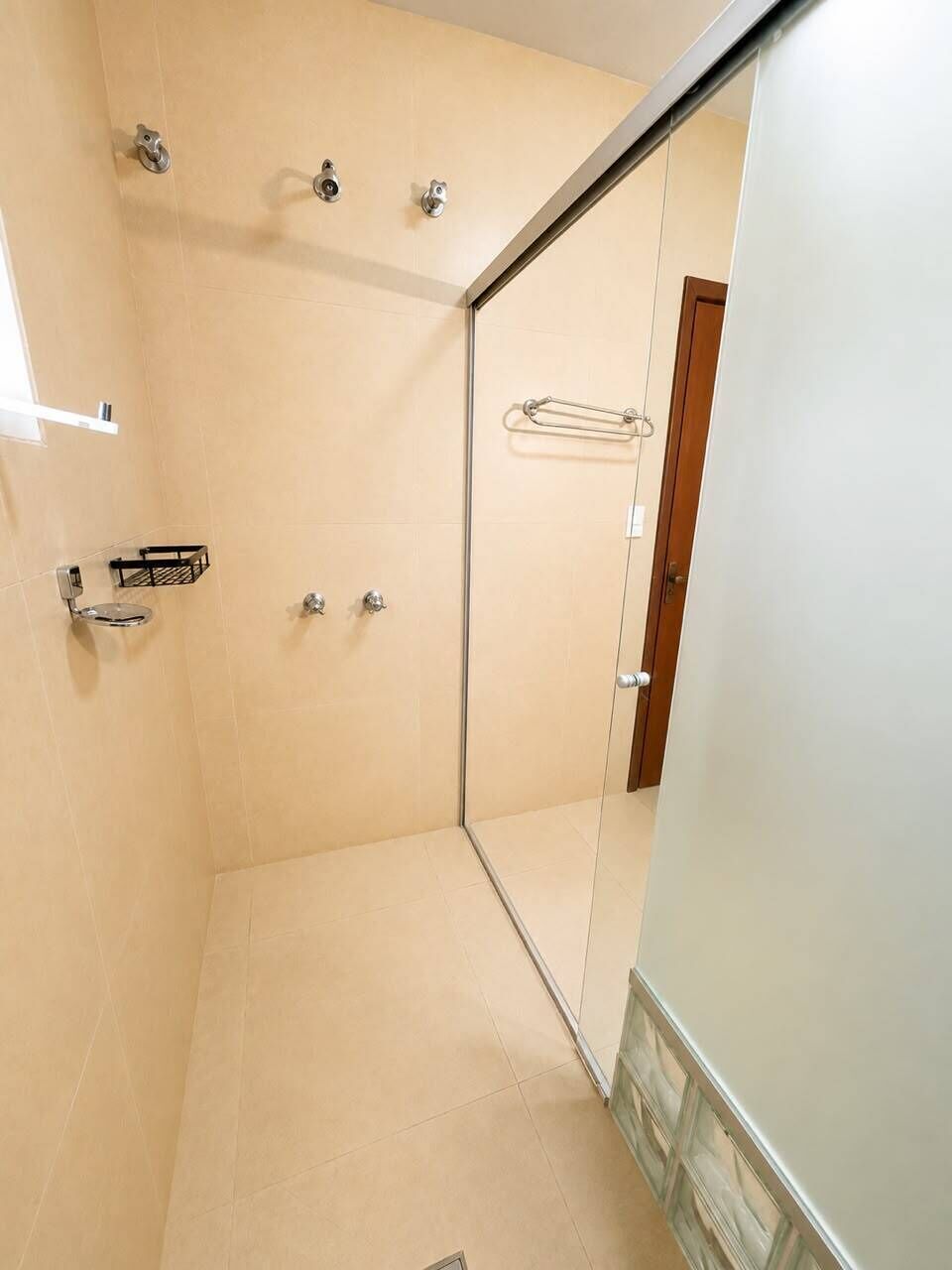 Un baño con ducha, toallero y retrete.