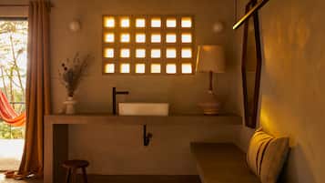 A bathroom with a sink, mirror, and a window with a grid pattern.