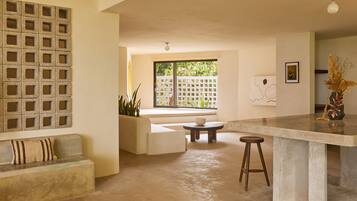 A modern interior with a concrete bench, a small round table, and a bar area.