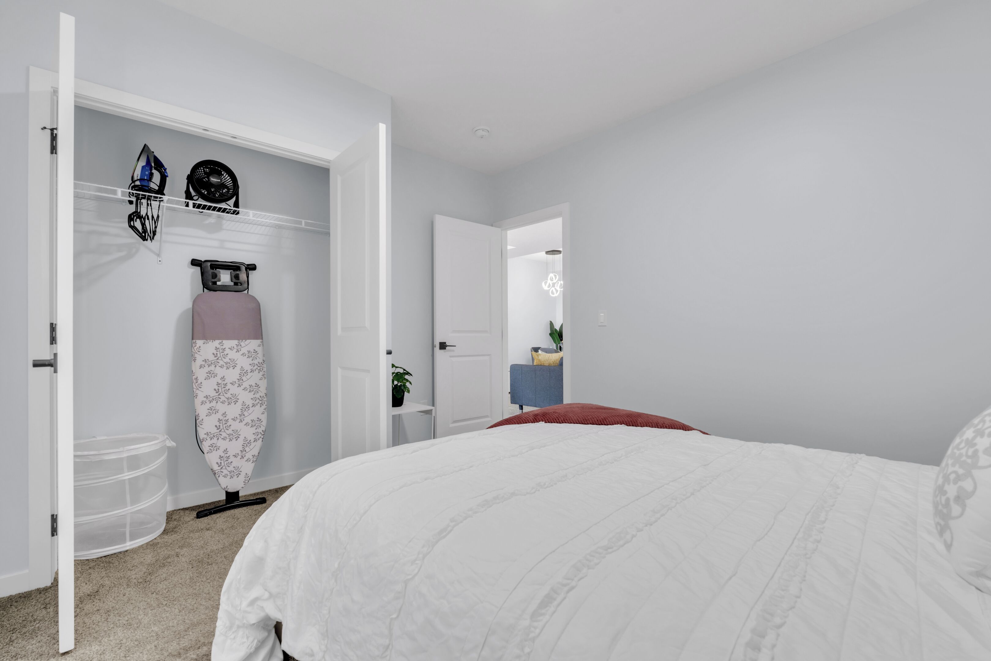 Een slaapkamer met een bed, een kast en een spiegel.