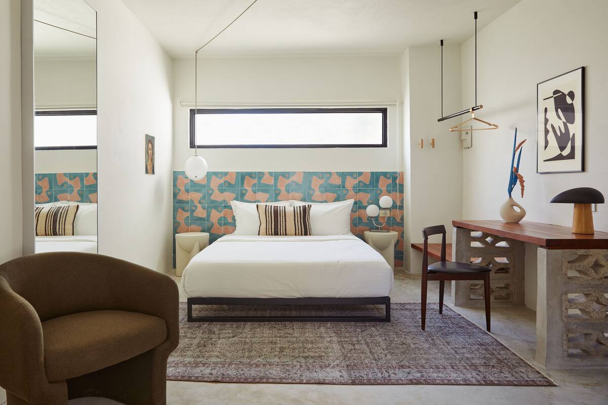 Une chambre à coucher moderne avec un grand lit, un bureau et une chaise.