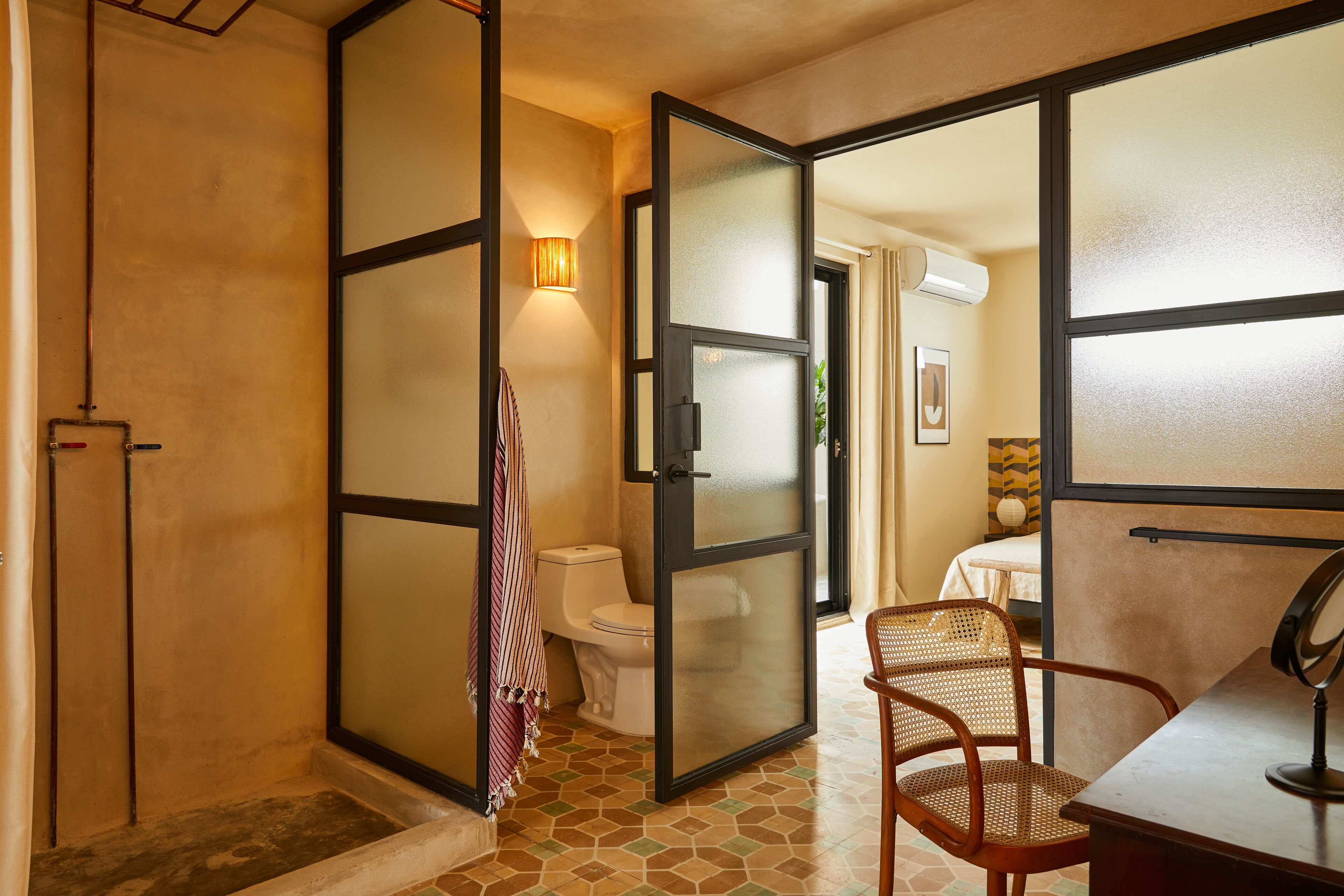 A bathroom with a toilet, a shower area, and a mirror.