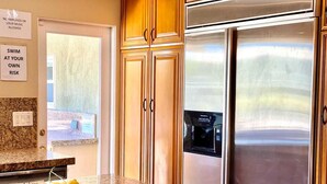 A kitchen with granite countertops, a stainless steel refrigerator, and a built-in microwave. - Palm Springs Oasis! Private, spacious, pool, spa, sauna shower! (Palm Springs)