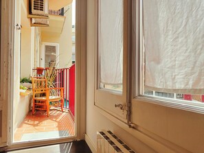 A narrow hallway with a door leading to a balcony.