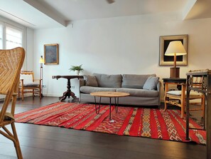 A living room with a sofa, a coffee table, a patterned rug, and a lamp.