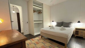 Une chambre à coucher comprenant un lit, des tables de chevet, une armoire et un bureau.