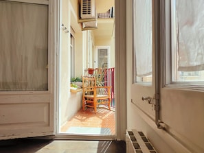 A narrow hallway with a door leading to a balcony.