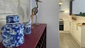 Une cuisine avec des meubles blancs, un sol à motifs et un meuble en bois sur lequel sont posés des récipients en céramique.