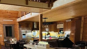 Eine gemütliche Küche mit Holzboden, einem Essbereich, einer Bar und einer Sitzecke.