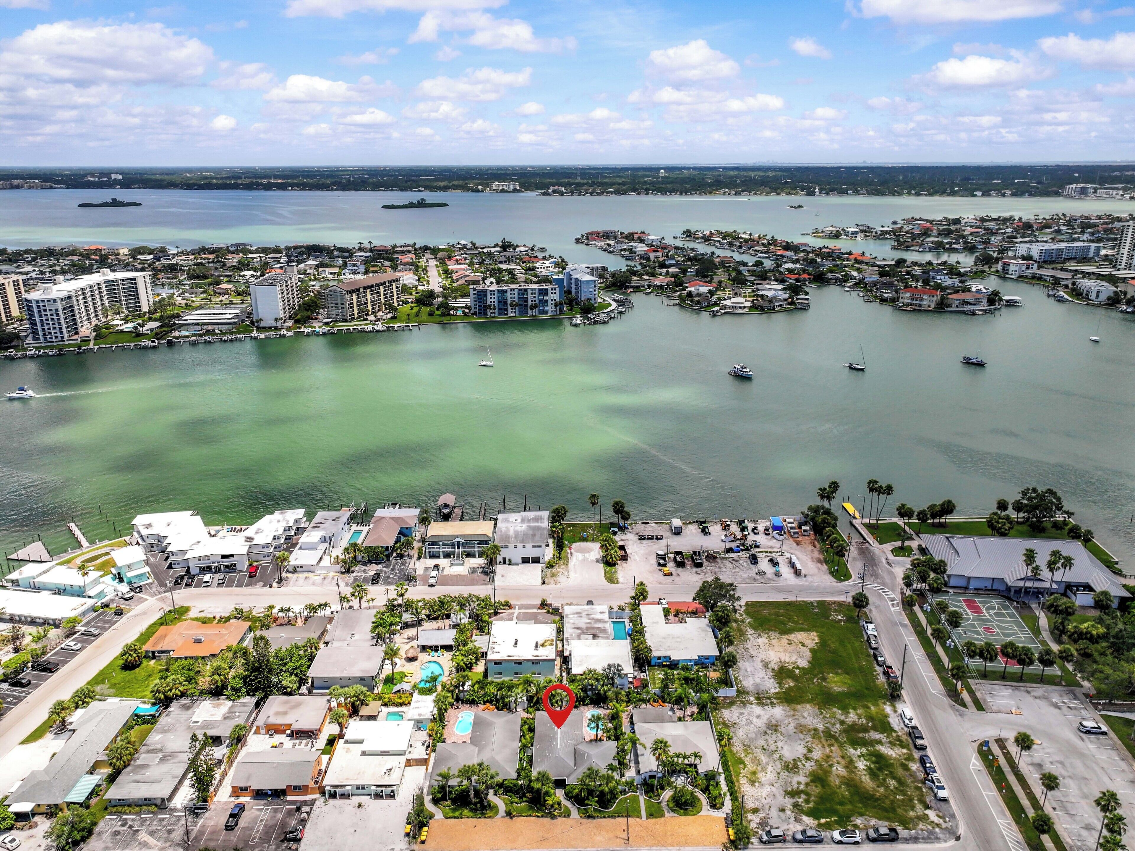 Une vue aérienne d’une ville côtière avec un port de plaisance, des bâtiments et une vaste étendue d’eau.