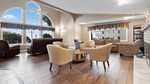 A spacious living room with a fireplace, large windows, and a ceiling fan. - Harbor View! Walk Out The Door Into Downtown Lex! (Lexington)