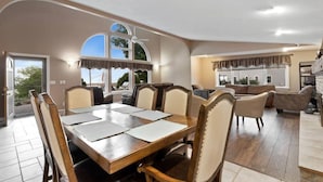 A spacious dining area with a wooden table and chairs, a kitchen area with a built-in oven, and a living room with a sofa and a TV. - Harbor View! Walk Out The Door Into Downtown Lex! (Lexington)