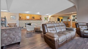 A spacious living room with a fireplace, leather sofas, and a dining area with a kitchen in the background. - Harbor View! Walk Out The Door Into Downtown Lex! (Lexington)