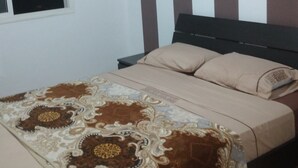 Une chambre à coucher avec un lit, une fenêtre et un mur à rayures.