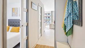 A hotel corridor with a bed, a door, and a wall with towels and a hat. - Downtown Cannes, Modern 1-Br. Apartment (Cannes)
