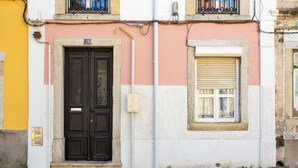 A building with a black double door, a small window with shutters, and a number '29' above the door.