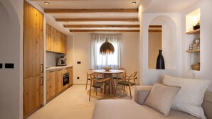 Um quarto acolhedor com cozinha de madeira, uma mesa de jantar com cadeiras e um sofá com almofadas.