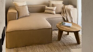 Uma sala de estar aconchegante com um sofá, uma mesinha e um ventilador de teto.