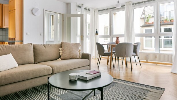 Una sala de estar moderna con un sofá, una mesa de centro y un comedor con sillas y una mesa.