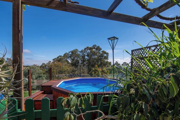 Une piscine extérieure dotée d’une terrasse en bois et d’une pergola au-dessus.