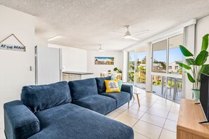 A modern living room with a sectional sofa, a dining area, and a balcony with a view. - Edmund Shores 6 Walk To Kings Beach, Ocean Views (KINGS BEACH)