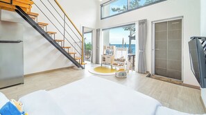 A modern interior with a staircase, a dining area, and a view of the sea. - Yeosu Sea&blue Family Pension (Yeosu)