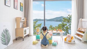 A child's play area with a view of a lake and mountains. - Yeosu Sea&blue Family Pension (Yeosu)