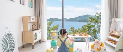 A child's play area with a view of a lake and mountains.