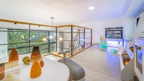 A modern room with large windows, a play area with toys, and a gaming console. - Yeosu Sea&blue Family Pension (Yeosu)