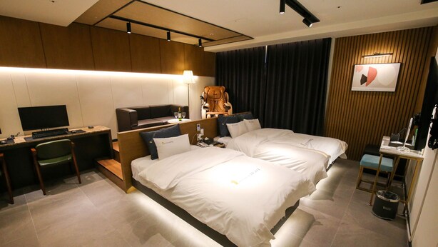 A modern hotel room with a large bed, a desk with a computer, a chair, and a TV. - Chungjangro 1st Boutique Hotel (Gwangju)