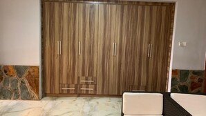 Une pièce dotée d’une grande armoire, d’un mur en pierre servant d’élément décoratif et d’un sol en marbre.