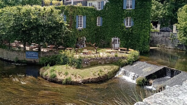 A riverside building with a stone bridge, a small waterfall, and lush greenery. - Chez Goret Gites - Gite Skippy  Couples only (Nouvelle- Aquitaine)