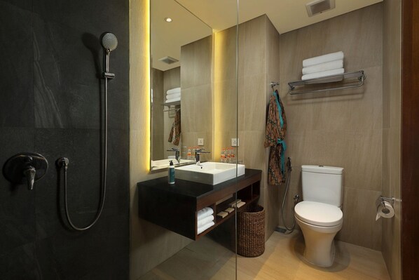 Un baño moderno con ducha, lavamanos e inodoro.