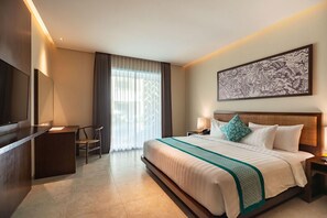 Una habitación de hotel con una cama, un escritorio, una silla, un televisor y una ventana con cortinas.
