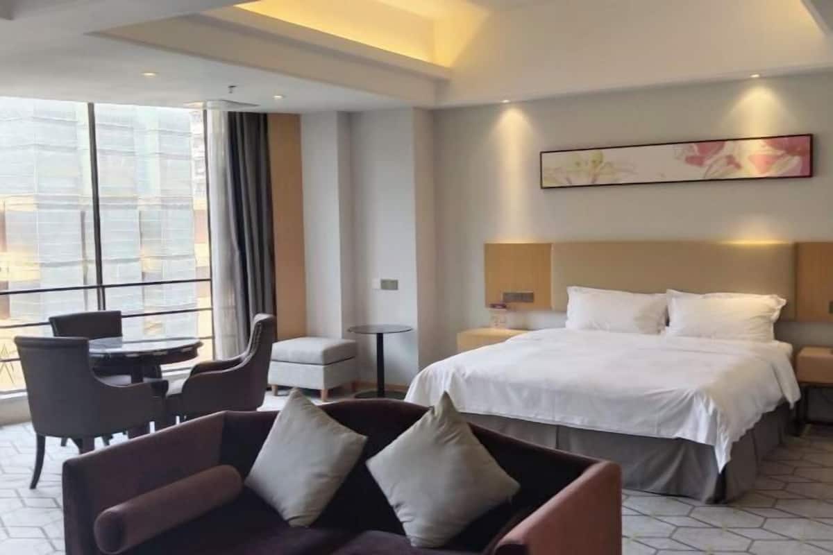 Une chambre d’hôtel comprenant un lit, un canapé, une table à manger et une chaise.