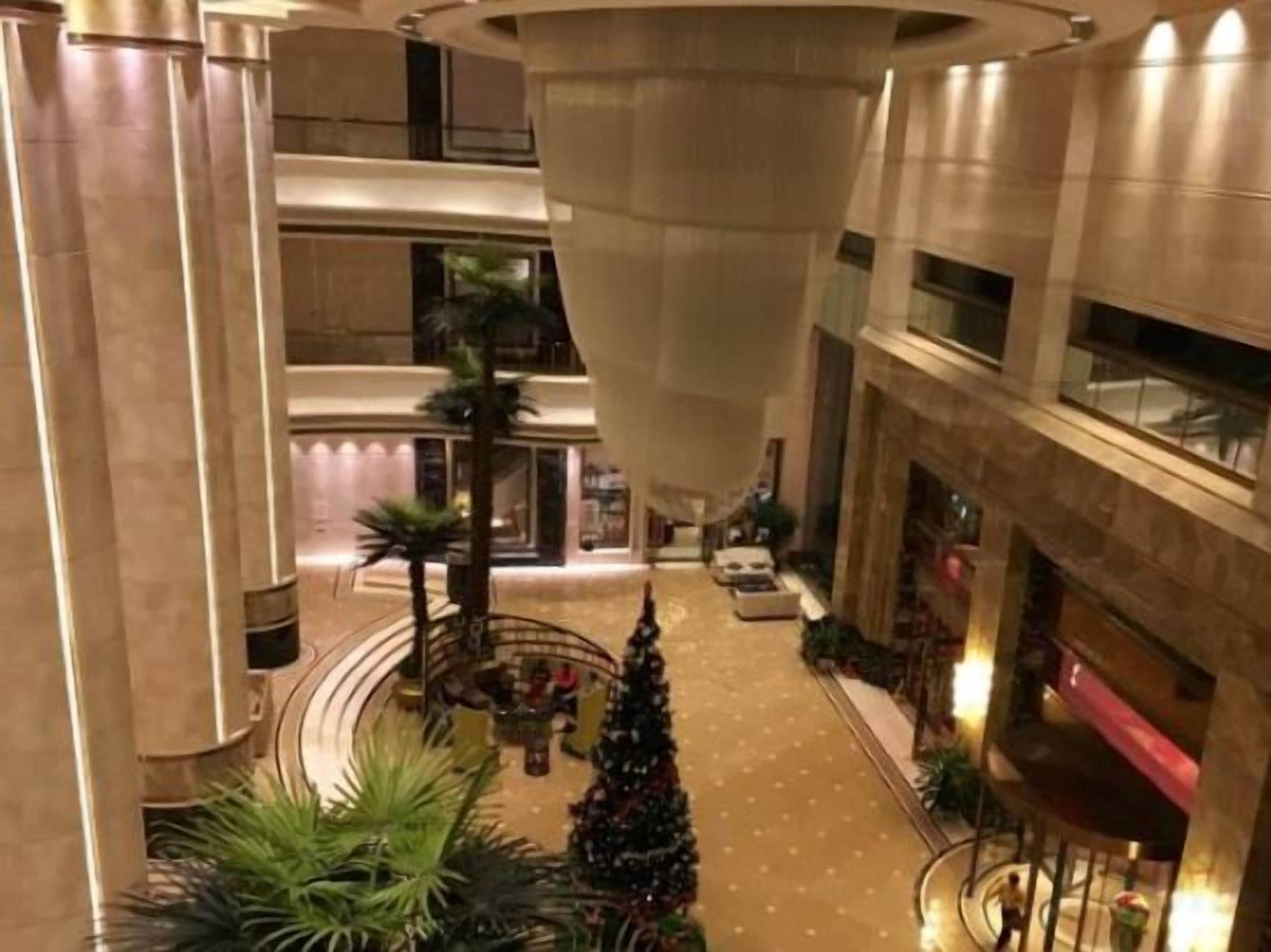 Un atrio de varios niveles con una columna central, un árbol de Navidad y una zona de estar.