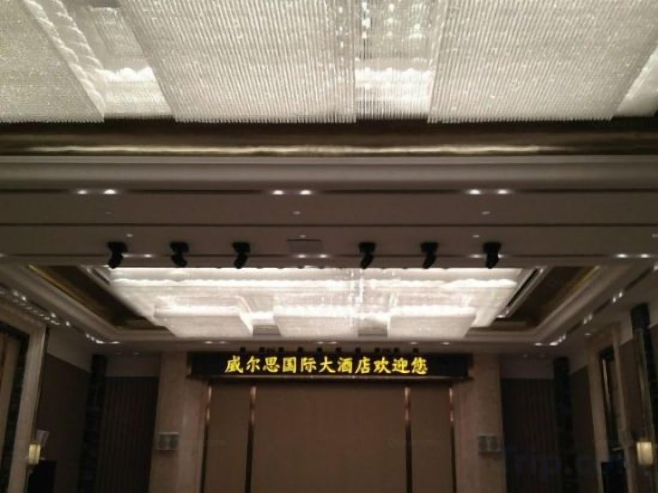 Entrada de un hotel con una araña y un cartel que indica una ubicación en China.