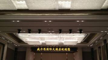 Entrada de un hotel con una araña y un cartel que indica una ubicación en China.