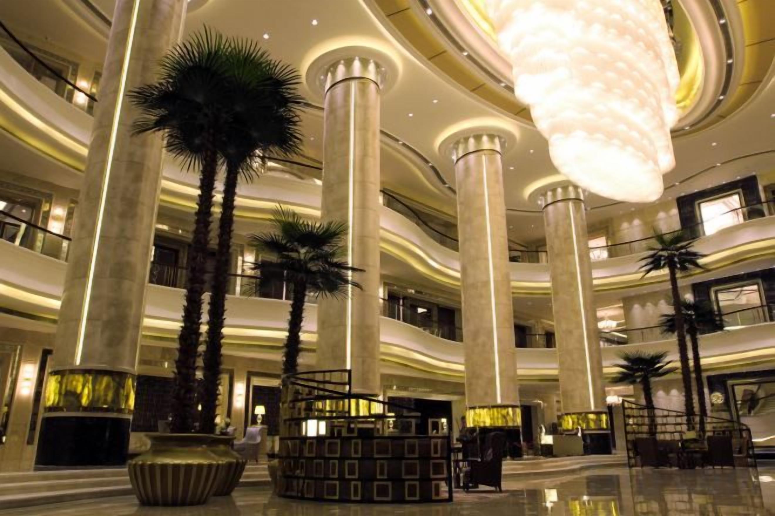 A multi-level atrium with high ceilings, large columns, and modern lighting fixtures.
