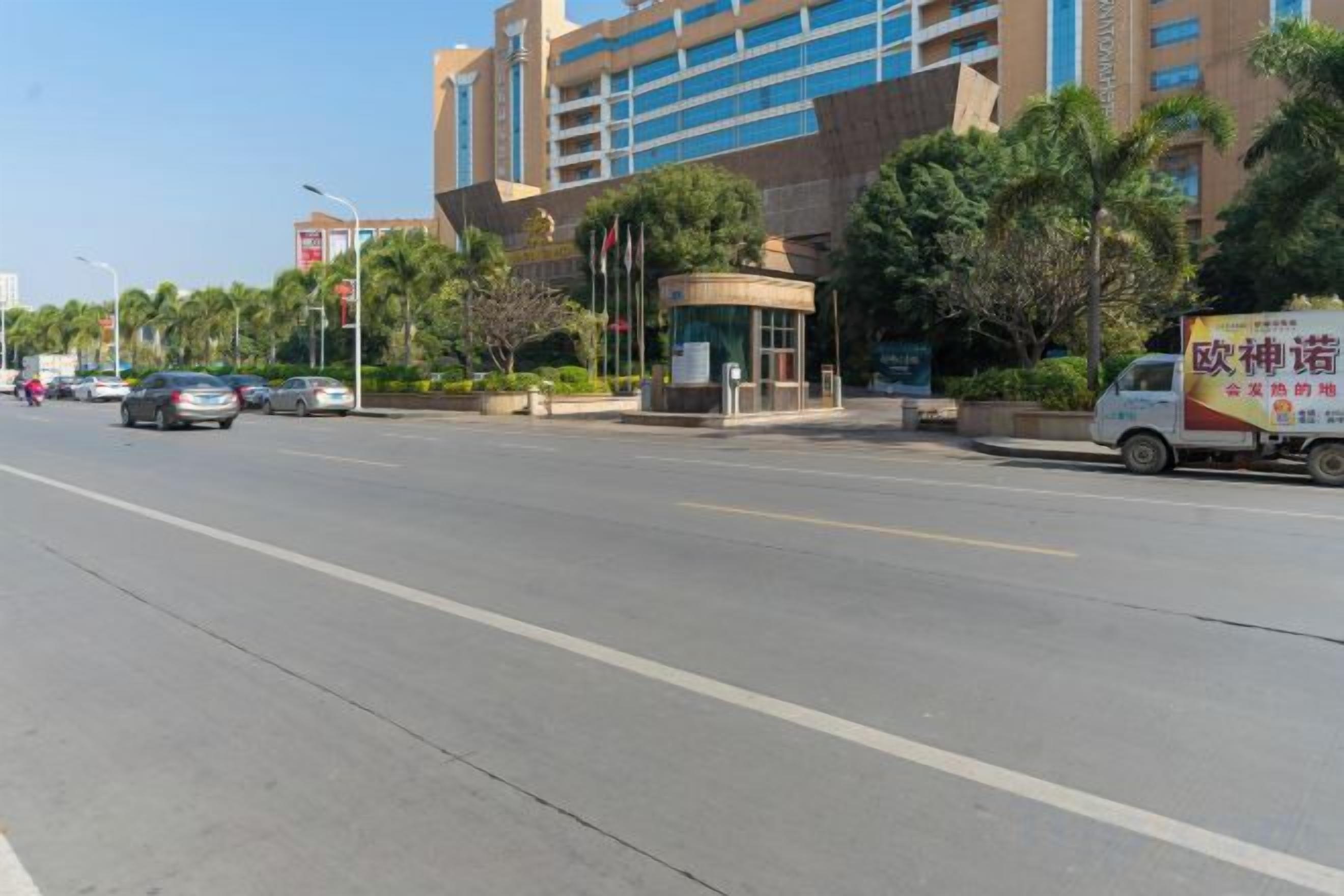 A street view with a modern building, a bus stop, and a delivery truck.