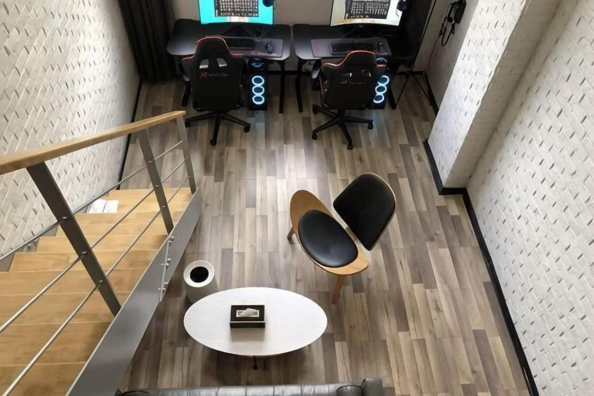 A modern office space with a staircase, two round tables, and office chairs.