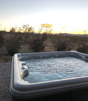 Ein Whirlpool im Freien mit freiem Blick auf den Sonnenuntergang.