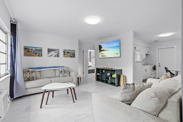 Living room with 65 inch TV. And two large couches.